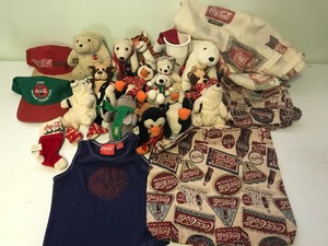 lot 84 image: Coca Cola plush figurines, hats, bag, fabric, tank top and shower curtain
