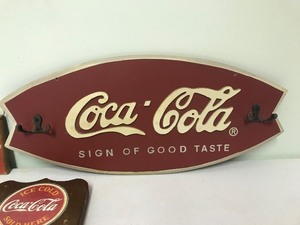 lot 98 image: Coca Cola coat rack, wood sign and wall hanging sign with pamphlet