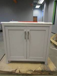 lot 176 image: Home Decorators Collection Rockleigh 36 in. W x 22 in. D Bath Vanity in Pebble Grey with Marble Vanity Top in Carrara White with White Basin (TOP IS CRACKED IN SEVERAL PLACES, MISSING SHELF IN CABINET)