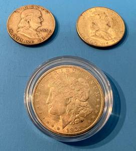 lot 142 image: 1921 Morgan Silver Dollar No Mint Mark In Plastic Protector And 2 Franklin Half Dollars 1 1951s 1 1953D