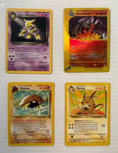 lot 299 image: 1999, 2000,2002 Pokemon Trading Cards Including Kabuto, Raichu, Houndoom And Dark Alakzam In Protective Sleeves