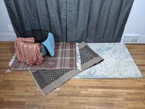 A Collection of Rugs and a Metal Basket
