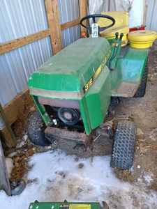 lot 43 image: John Deere 318 Lawn Tractor with 46-inch Mower Deck, 38-inch Thatcher, and a Pair of Rear Wheel Weights, Missing Grille