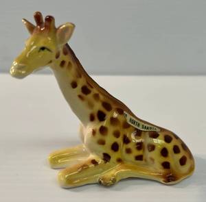lot 229 image: Vintage Ceramic Giraffe With Partial Foil Label North Dakota 3 12 T x 3 12 W