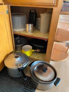 lot 145 image: Contents of Kitchen Cabinet Presto Pressure Cooker, Vintage Flour Sifters and More