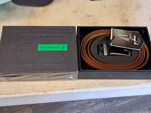 lot 1138 image: Lot of (2) Mio Marino The Quest Collection Burnt Umber Genuine Leather Rectangular Classic Linxx Belts (in original packaging)