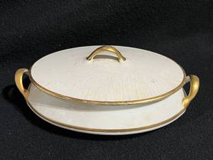 lot 139 image: Homer Laughlin 18K Gold and Cream Gravy Boat, Serving Dish, and Gibson Teacups