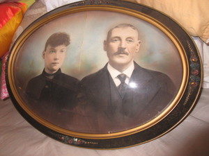 lot 927 image: ANTIQUE OVAL FRAME WITH RAISED FLORAL DESIGN AND HAND TINTED PHOTO