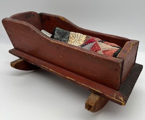 lot 172 image: Vintage Primitive Red Wood Doll Cradle with Doll Quilt
