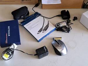 lot 713 image: Logitech Camera, Jabra Earbuds, RTi Wireless Computer Mouse, EnGenius Network Equipment, Insignia Universal File Transfer Cable, Netgear ProSafe 8 Port Gigabit Switch GS108