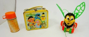 lot 29 image: Vintage 1979 Sesame Street Lunch Box by Aladdin, Kusan Plastic Bee Pull Toy