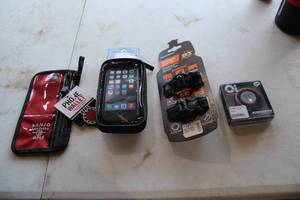 lot 476 image: Lot of (4) Bike Accessories (in original packaging) - Banjo Brothers Phone Wallet, BiKase Handy Andy 5 Phone Case, Oi Bicycle Bell, Anywere Adapter