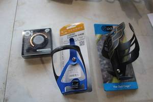 lot 480 image: Lot of (3) Bike Accessories (in original packaging) - Oi Bicycle Bell, Serfas Carbin Cage Bottle Holder, The Owl Cage Bottle Holder