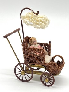 lot 97 image: Vintage Artisan Barbara J. Rumeli Wicker Baby Carriage and Miniature Doll