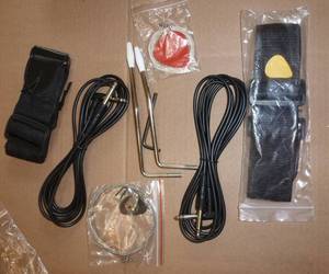 lot 108 image: 2 electric guitar accessory kits, 2 sets of strings and picks, strap, amp plug
