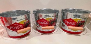 lot 194 image: 3 Coca-Cola Tins, 6 Plastic Coke Cups, And 2 Four Pack Glass Bottle Sets