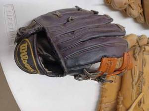 lot 55 image: Five Leather Baseball Gloves, Softballs, Footballs, Aluminum Bat, Hockey Pucks and More