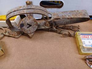 lot 131 image: Box of Fishing Items, Hunting Items, and a Vintage Victor Gopher Trap, a Leather Holster, Pheasant Feathers, Vintage Reel