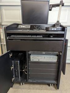 lot 7 image: Presentation Podium on Wheels With Equipment - Magnavox DV225MG9 DVD Player and 4 Head Hi-Fi Stereo VCR, Samsung SDP-860 SXGA Digital Presenter, Exetron Tuner & Switch, HP PC