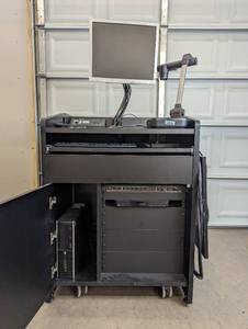 lot 9 image: Presentation Podium on Wheels With Equipment - Panasonic Dmp-bd91 Blu Ray Player, Samsung SDP-860 SXGA Digital Presenter, Exetron Tuner & Switch, HP PC