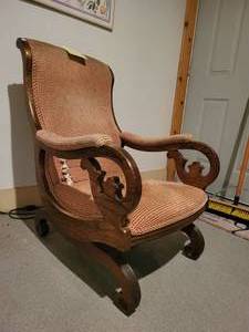 Upholstered Antique Rocking Chair with nicely carved woodwork.