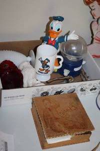 lot 595 image: Donald Duck Statue, Donald Duck Mug, Mini Gumball Machine, Milk White Vase, White Owl Statue, Red Vase, Metal Deer, Box with Linens