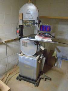 lot 114 image: Delta 14 band saw on rolling cart. Extra blades. 110 v with fence & miter. Can take extension for deeper throat. Model 28-254. As shown.