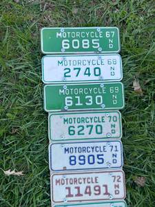 lot 23 image: Board Full of Motorcycle License Plates Starting with ND 1967