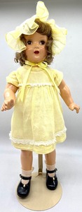 lot 39 image: Composition Doll in Yellow Dress & Bonnet with a Vintage Wood Doll Dresser