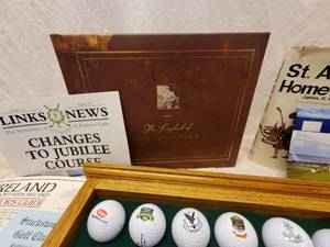 lot 158 image: Golf Lot #1-Golf Ball Display Rack with many balls--most from Scotland. Legend of Old Tom Morris and other books, scorecards, brochures and golf balls--mostly from Scotland, including St. Andrews, Carnoustie, Glen Eagles and more.