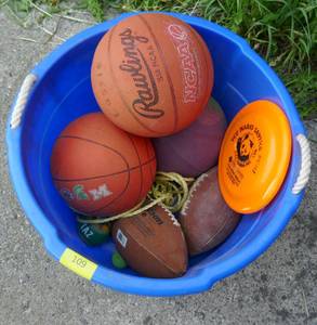 lot 109 image: New plastic bushel basket full of basketballs and footballs