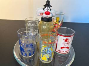 lot 149 image: 5 assorted fun vintage drinking glasses incldg. The Archies, Wizard of Oz, Superman, Pussy Power  Sylvester water bottle on thick glass plate