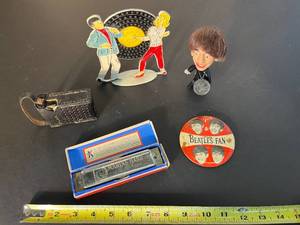 lot 192 image: Make some music  vintage Official Beatles Fan pin, Ringo Starr doll, Marine Band harmonica, Bulova transistor radio & Disco Beat pierced earrings stand