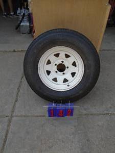 lot 142 image: 2157514 trailer tire & wheel. 5 hole. Looks almost new. As shown.