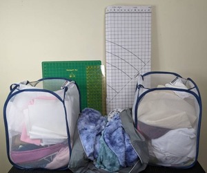 lot 25 image: CraftingSewing Supplies  Pattern & Craft Board, Omnigrid, Omnigrid Mat, Fabric, (2) Soft-Sided Storage Bins