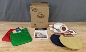 lot 103 image: NEW Ginnys Ice Cream Maker, Woven Trivets, Measuring Cups, and More Kitchen Items K