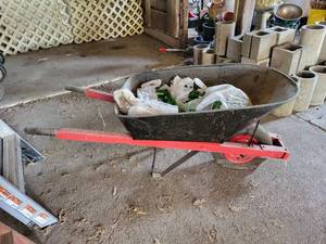 lot 432 image: Pneumatic Tire Wheelbarrow with Many Green Glass Bottles for Bottle Tree