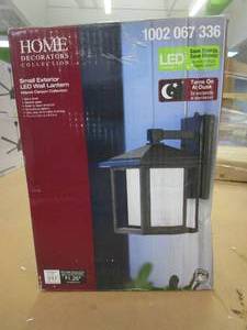 lot 74 image: Home Decorators Collection Mauvo Canyon Black Dusk to Dawn Small LED Outdoor Wall Light Fixture with Seeded Glass (OPEN BOX)
