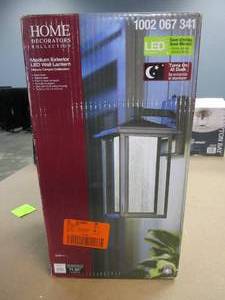 lot 133 image: Home Decorators Collection Mauvo Canyon Black Dusk to Dawn LED Outdoor Wall Light Fixture with Seeded Glass (OPEN BOX)