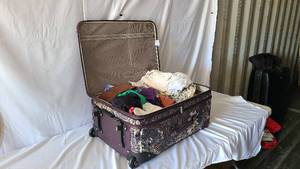 Fancy suitcase full of clothes in g...