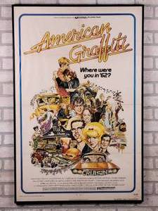 lot 504 image: Original 1973 Framed American Graffiti 27x41 Movie Poster - Richard Dreyfuss, Ronny Howard, Wolfman Jack, and Harrison Ford (Not even credited on the poster)