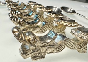lot 68 image: Set of Six White Metal Chopstick Holders and Six Ornate Spoons