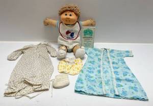lot 131 image: 1986 Vintage Cabbage Patch Doll With Birth Certificate & Adoption Application And More Including Extra Clothes