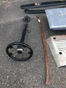 lot 5 image: Huge Parts Lot Includes - Steering Column with great steering Wheel - 1965 Mustang Gas Tank - 1967 Camaro RS Lower Valance - 1970 Chevelle Headlite benzel - 1966 Chevy Horns - flex plate Chevy 1968-72 Chevelle trunk filler panel