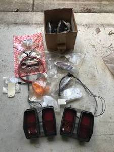 lot 97 image: Huge lot of Parts - Includes  More - 1970 Cutlass tail lights, New Headlights, Shift cable Kit, Misc. Chevy Parts  More