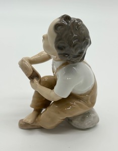 lot 322 image: Bing & Grndahl Boy Putting on Shoe Porcelain Figurine  (Brown and White) #2275