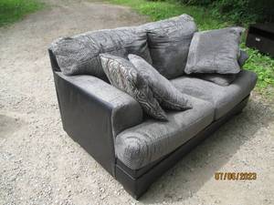 lot 159 image: Gray Upholstered 2-cushion Sofa with accent pillows and a pleather back and sides