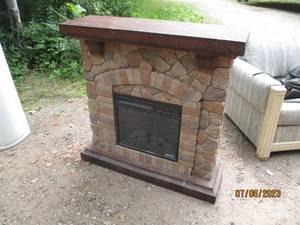 lot 162 image: Full faced bricked front 120v electric Fireplace complete with wood mantle and bottom trim