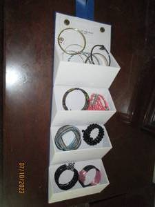 lot 102 image: hangable fold-out jewelry box with a variety of bracelets