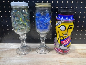 lot 54 image: Glass Jars of Marbles and Mr. Peanut Container